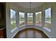 Bright breakfast nook with hardwood floors surrounded by windows overlooking the back yard at 14538 Baldwin Ln, Carmel, IN 46032