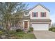 Charming two-story home with a brick facade, red shutters, and a well-maintained front lawn, offering great curb appeal at 14538 Baldwin Ln, Carmel, IN 46032