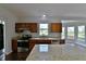 Granite countertops, stainless steel appliances, and dark wood cabinets in this large open kitchen at 14538 Baldwin Ln, Carmel, IN 46032