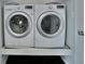 A close up of a new, white washer and dryer in a small laundry room at 14538 Baldwin Ln, Carmel, IN 46032