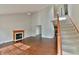 Living room with hardwood floors, fireplace, staircase, and views to the kitchen and 2nd story at 14538 Baldwin Ln, Carmel, IN 46032