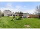 Spacious backyard with green grass, a playground set, storage shed, and wood privacy fence at 14953 Lovely Dove Ln, Noblesville, IN 46060