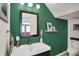 Modern bathroom featuring green walls, a stylish mirror, and sleek fixtures at 1826 N Alabama St, Indianapolis, IN 46202