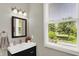 Stylish bathroom vanity featuring a modern sink, black framed mirror and bright window with natural lighting at 1826 N Alabama St, Indianapolis, IN 46202