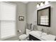 Well-lit bathroom with a modern vanity, large mirror, and a window providing natural light at 1826 N Alabama St, Indianapolis, IN 46202