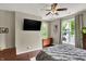 Spacious bedroom featuring hardwood floors, a ceiling fan, and a view of an outdoor scene at 1826 N Alabama St, Indianapolis, IN 46202