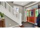 Bright foyer featuring a staircase, coat rack, and stylish front door at 1826 N Alabama St, Indianapolis, IN 46202