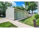 View of the light green detached garage with well-manicured landscaping and a cement walkway at 1826 N Alabama St, Indianapolis, IN 46202