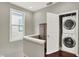 Upstairs hallway with a storage cabinet and a stackable washer and dryer at 1826 N Alabama St, Indianapolis, IN 46202
