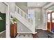 Bright entryway with hardwood floors and a staircase with white wood trim at 1826 N Alabama St, Indianapolis, IN 46202