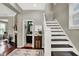Bright entryway with hardwood floors and a staircase with white wood trim at 1826 N Alabama St, Indianapolis, IN 46202