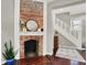 Cozy living room with a brick fireplace, hardwood floors, and staircase at 1826 N Alabama St, Indianapolis, IN 46202