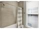 Neutral toned bathroom with a shower and modern shower curtain, and natural light from the window at 1826 N Alabama St, Indianapolis, IN 46202