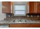 Well lit kitchen featuring stainless steel sink, wood cabinets, and mosaic backsplash at 1839 Silverton Dr, Avon, IN 46123