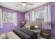 Bedroom with purple walls, two windows, ceiling fan, and neutral-toned furniture at 1933 Ruth Dr, Indianapolis, IN 46240