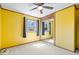 This bedroom features yellow walls, a ceiling fan, a mirror closet, and one window at 1933 Ruth Dr, Indianapolis, IN 46240