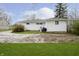 Backyard view featuring a white home with gravel and grass, and lush green bushes at 217 S 17Th Ave, Beech Grove, IN 46107