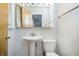 Cozy bathroom featuring a pedestal sink, mirrored cabinet, and toilet for a clean, minimalist style at 217 S 17Th Ave, Beech Grove, IN 46107