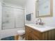 Bright bathroom with white vanity, wood accents, modern fixtures, shower/tub combo and frosted glass doors at 217 S 17Th Ave, Beech Grove, IN 46107