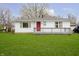 Charming single-story home with a red front door, white siding, and a well-manicured lawn at 217 S 17Th Ave, Beech Grove, IN 46107