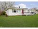 A cozy one-story home with white siding, complemented by a lush green lawn at 217 S 17Th Ave, Beech Grove, IN 46107