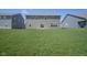 View of the rear exterior featuring a well-maintained lawn, and a sliding glass door for easy access at 2237 S Copperstone Dr, New Palestine, IN 46163