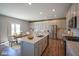 A bright kitchen featuring stainless steel appliances, a large island, and white cabinets at 2237 S Copperstone Dr, New Palestine, IN 46163