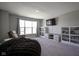 Neutral living room with large bright window, mounted TV, and casual seating on carpeted floor at 2237 S Copperstone Dr, New Palestine, IN 46163