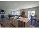 Open-concept living room with a fireplace, hardwood floors, and an island leading to the kitchen at 2237 S Copperstone Dr, New Palestine, IN 46163
