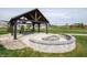 Community picnic area with a wooden shelter and a stone fire pit at 2249 Oakmont Dr, Plainfield, IN 46168