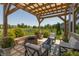 Backyard patio with a pergola, a fire pit, seating, lush greenery, and pond views at 2325 Silver Rose Dr, Avon, IN 46123
