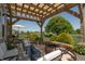 Backyard patio with a pergola, a fire pit, seating, lush greenery, and lake views at 2325 Silver Rose Dr, Avon, IN 46123