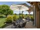 Backyard patio with an umbrella, a dining set, lush greenery, and lake views at 2325 Silver Rose Dr, Avon, IN 46123