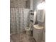 Well-lit bathroom with a patterned shower curtain, gray backsplash, white vanity, and coordinated storage at 2325 Silver Rose Dr, Avon, IN 46123