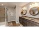 Bathroom featuring double sink vanity, a shower, decorative rugs, and neutral paint at 2325 Silver Rose Dr, Avon, IN 46123