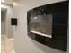 Modern wall-mounted fireplace with sleek black glass design in the finished basement at 2325 Silver Rose Dr, Avon, IN 46123
