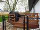 Backyard deck with wooden railing, covered grill, and enclosed with black chain link fence at 2416 Depauw Rd, Indianapolis, IN 46227