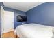 Bedroom featuring blue walls, hardwood floors, TV, and a door to the side at 2416 Depauw Rd, Indianapolis, IN 46227