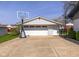 View of the detached garage with a basketball hoop and a wide driveway for easy parking at 2416 Depauw Rd, Indianapolis, IN 46227