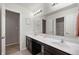 Well-lit bathroom with double sinks, a large mirror, and neutral tile flooring at 2681 Pumpkin Patch Ln, Indianapolis, IN 46229