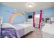 Charming bedroom features rainbow wall art, a window with curtains, and light blue walls at 2681 Pumpkin Patch Ln, Indianapolis, IN 46229