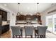Modern kitchen featuring a central island, stainless steel sink, stylish pendant lighting, and dark brown cabinetry at 2681 Pumpkin Patch Ln, Indianapolis, IN 46229