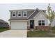Well-maintained two-story home with gray siding, a two-car garage, and a neatly landscaped yard at 2704 Grassy Br Dr, Whitestown, IN 46075