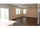 Open-concept living room with dark wood floors and sliding glass doors leading to the backyard at 2704 Grassy Br Dr, Whitestown, IN 46075