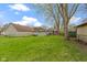 This backyard has a large green lawn with scattered trees and views of the neighboring houses at 304 W 4Th St, Greenfield, IN 46140