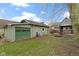 This is a backyard with a detached garage, wood deck with gazebo and a single blue chair at 304 W 4Th St, Greenfield, IN 46140