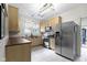 View of the stainless steel refrigerator and light wood cabinets in this eat-in kitchen with tile floors at 304 W 4Th St, Greenfield, IN 46140