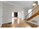 Bright living room featuring hardwood floors, archway, and wood staircase with natural light and neutral color palette at 304 W 4Th St, Greenfield, IN 46140