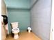 A bathroom featuring a toilet and a trashcan, set against a light blue painted brick wall at 3559 N Us Highway 41, Bloomingdale, IN 47832
