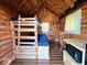 Cozy cabin interior with wood paneled walls, bunk beds, a small table, and a yellow checkered curtain at 3559 N Us Highway 41, Bloomingdale, IN 47832